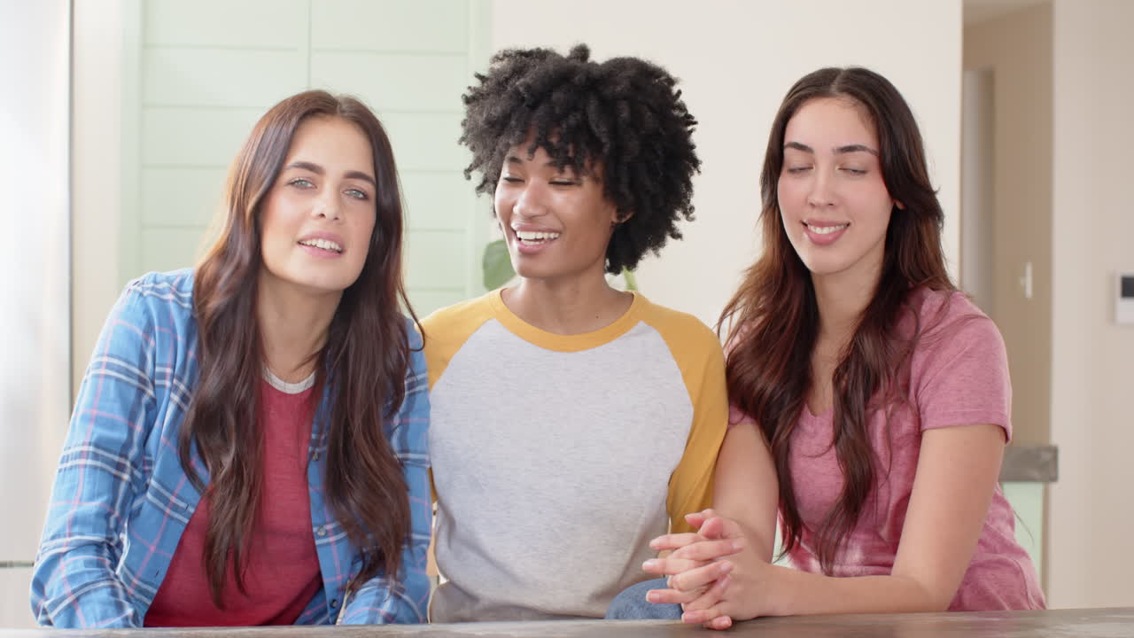 Tre amiche che ridono e si godono il tempo insieme a casa.