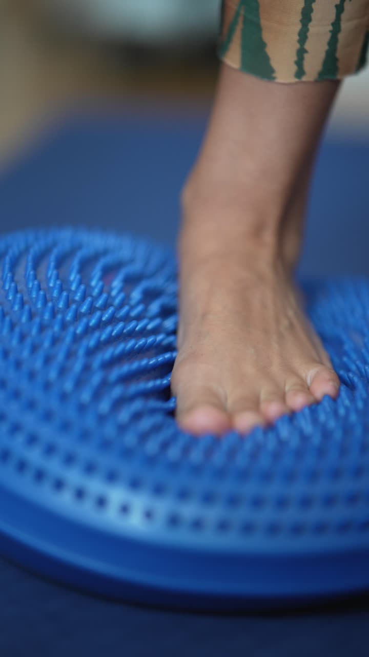 persona que practica ejercicios de equilibrio en un disco de equilibrio