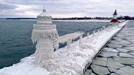 ice covered saint joseph lighthouse, winter evening in michigan, usa - aerial view