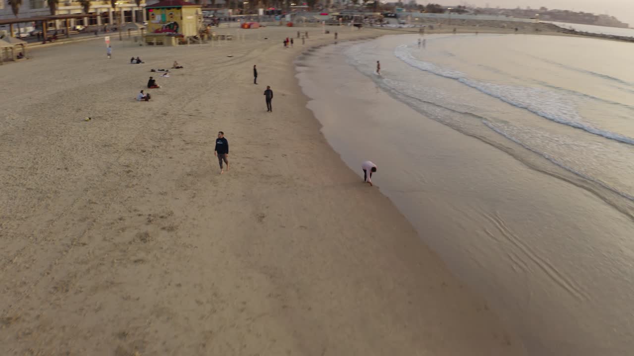 4k 항공 - 일몰 동안 텔아비브 해변에서 장엄한 궤도를 도는 사람들