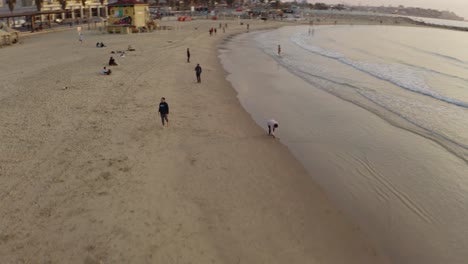 4k 항공 - 일몰 동안 텔아비브 해변에서 장엄한 궤도를 도는 사람들