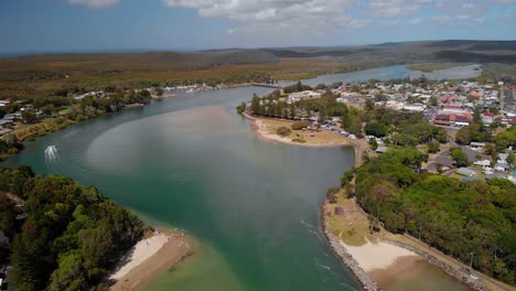 vista aérea sobre el río en el pueblo de evans head, día soleado - reversa, disparo de drones