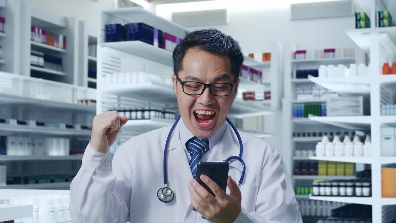 행복한 약사는 약국에서 스마트폰으로 성공을 축하합니다.