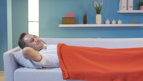 hombre en la cama riéndose de la cámara.