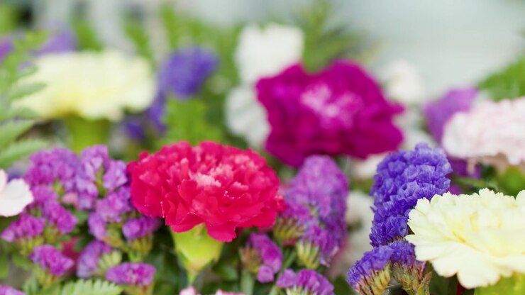 Primo piano di garofani rosa freschi e statice viola in un bouquet colorato al mercato di Bangkok