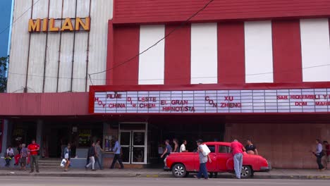 Los-Hombres-Cargan-Un-Coche-Viejo-Fuera-De-Un-Cine-En-La-Habana,-Cuba-1