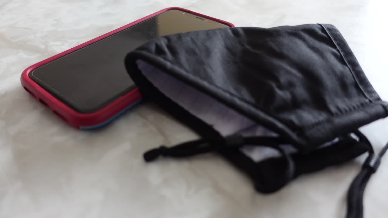 máscara negra un teléfono celular en el mostrador de mármol, sin personas