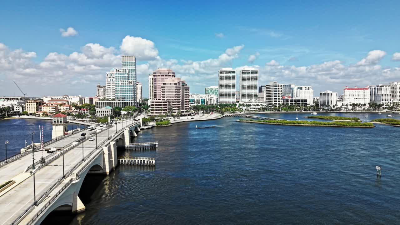 Aerial: cityscape with Royal Park Bridge, One Flagler and Phillips Point building during the day in West Palm Beach, Florida, USA, pull out drone shot