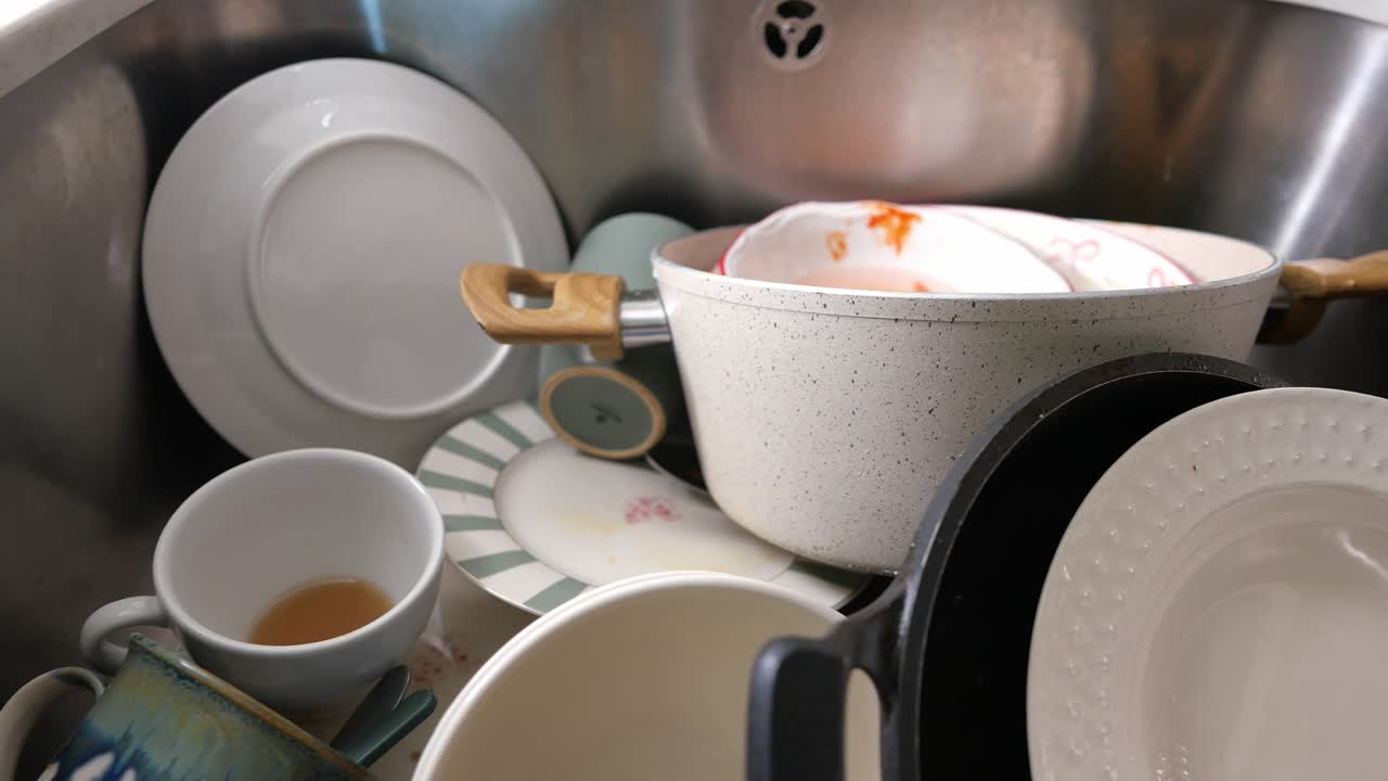 Messy Kitchen Sink Full of Dirty Dishes After a Meal