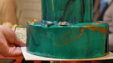 a beautiful, intricate, green marbled cake being cut.