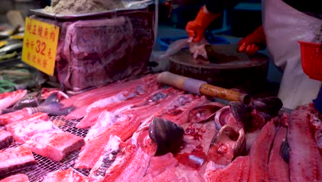 carnicero de mariscos cortando pescado en el mercado de pescado húmedo de mariscos asiáticos, pescado cortado muerto
