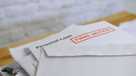 a stack of bills and letters with final notice for personal loan