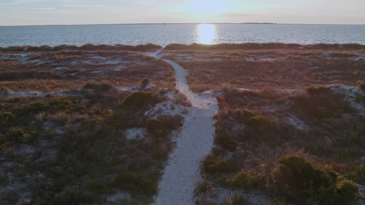 vuelo aéreo siguiendo un camino de arena a una playa en florida a través de dunas nativas naturales