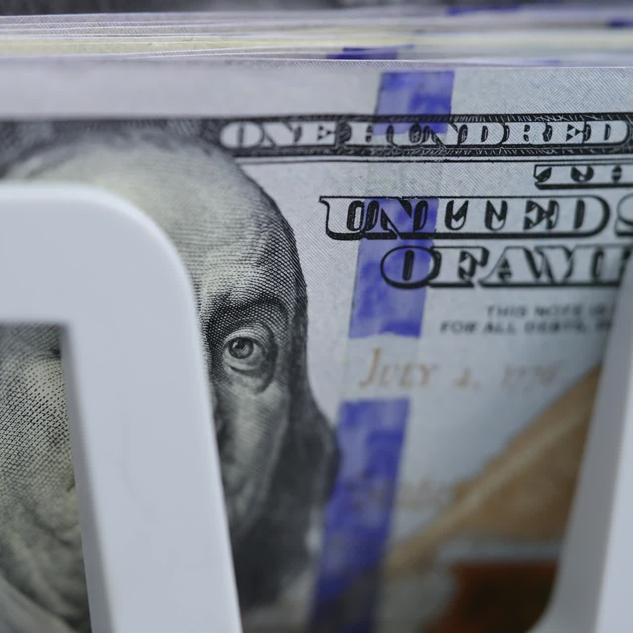 Cash money counting machine. Banknote counter are counting one hundred dollar bills. Macro shot