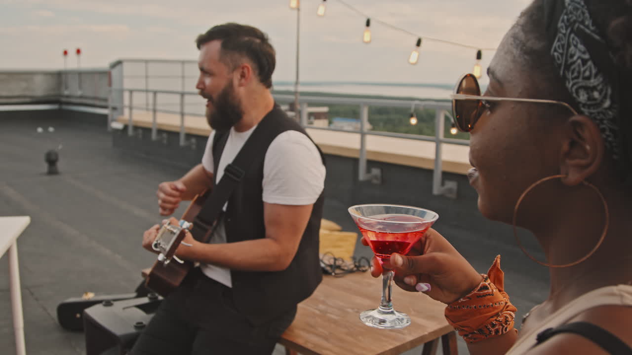 People Listening to Live Music at Rooftop Party