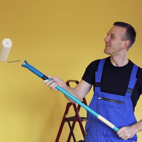 young man painting wall with roller brush while renovating his apartment. repair, building and home concept