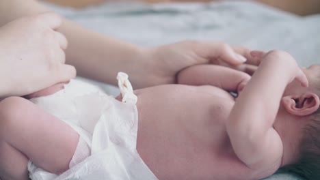 manos amorosas de la madre cuna bebé adorable en pañal blanco