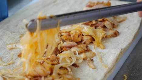 preparing a chicken and onion wrap