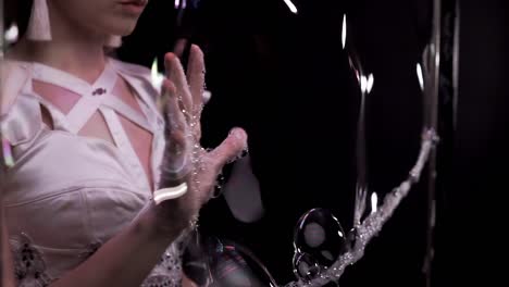 close up: girl does tricks with soap bubbles. she plays her hand on the soap screen on vertical frame