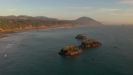 Drone-over-illuminated-sea-stacks-at-sunset-Oregon-Coast