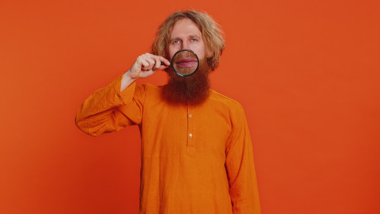 Happy smiling caucasian man holding magnifier glass on teeth health care hygiene stomatology concept