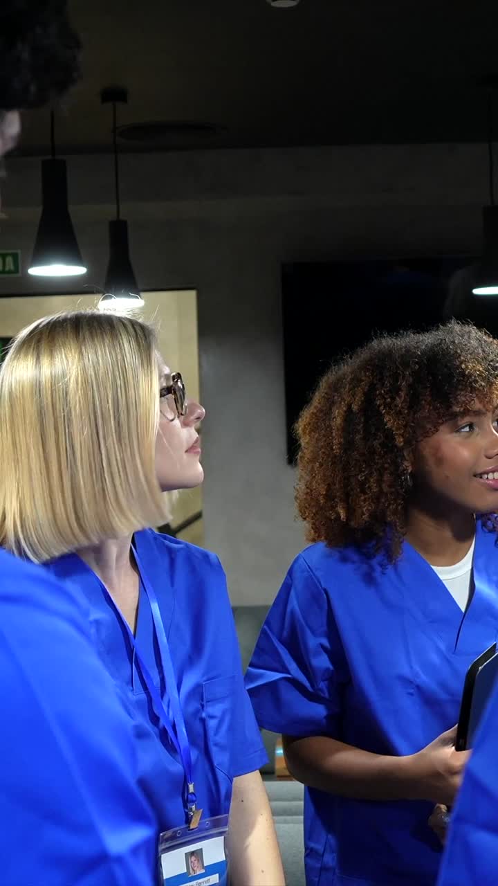 Jovens profissionais de saúde de uniforme cirúrgico tendo uma discussão.