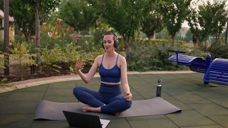 woman practicing online yoga in a park