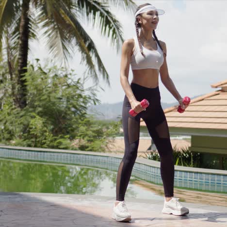 sportswoman squatting with dumbbells on poolside