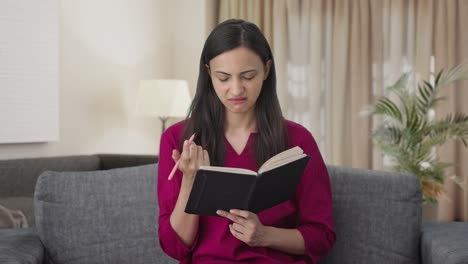 mujer india confundida escribiendo un libro
