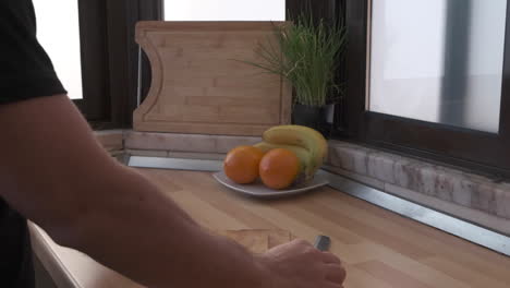 el hombre prepara una tabla de cortar de madera y un cuchillo en la cocina - cierre, cámara lenta