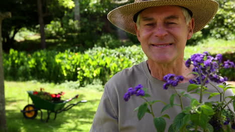 hombre jubilado jardinería y sonriendo a la cámara