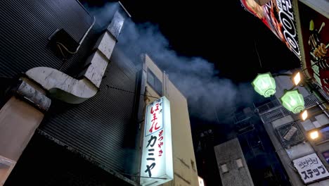 smoke billows among neon-lit city buildings at night.