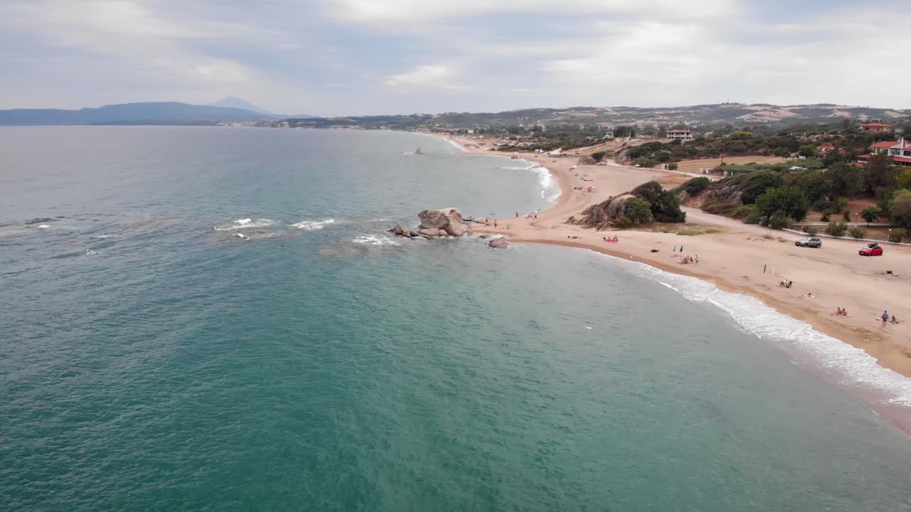 avión no tripulado de alta velocidad sobre la playa de mar de arena nublado día de verano formación de rocas de fondo