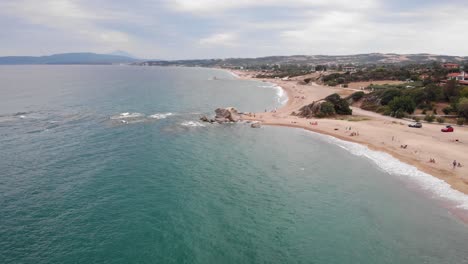 high-speed-drone-over-sandy-sea-beach-cloudy-summer-day-rocks-formation-background