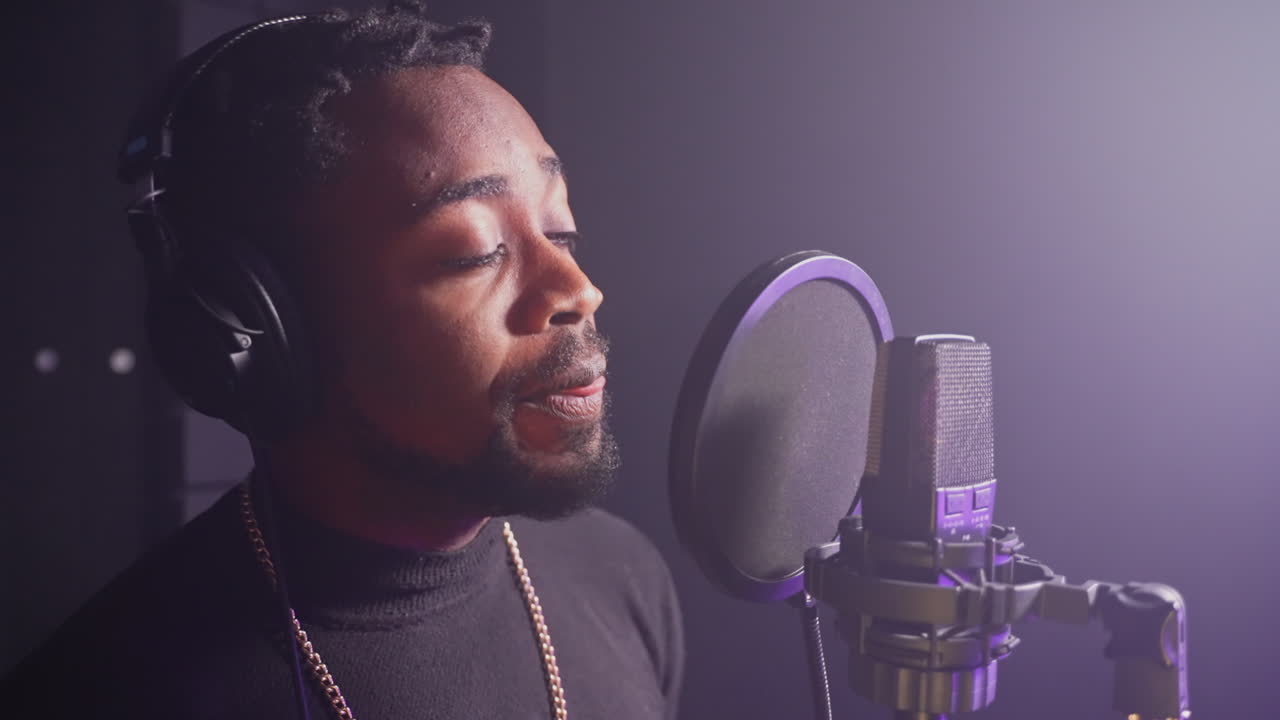 hombre cantando en el micrófono en el estudio de grabación