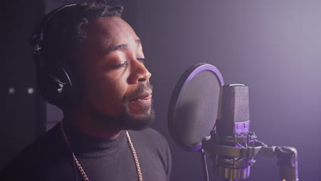 man singing into microphone in recording studio