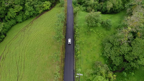 Luftschwenk-Nach-Oben,-Während-Das-Auto-Die-Ländliche-Zentralamerikanische-Straße-Hinunterfährt,-4k