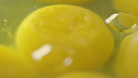 piercing a yolk into the remaining yolks with egg whites floating on the pan