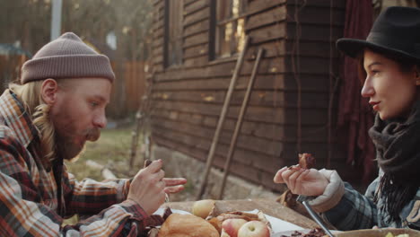 couple eating dinner outdoors and speaking