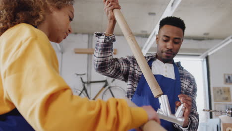 multi-cultural team in workshop assembling hand built sustainable bamboo bicycle frame