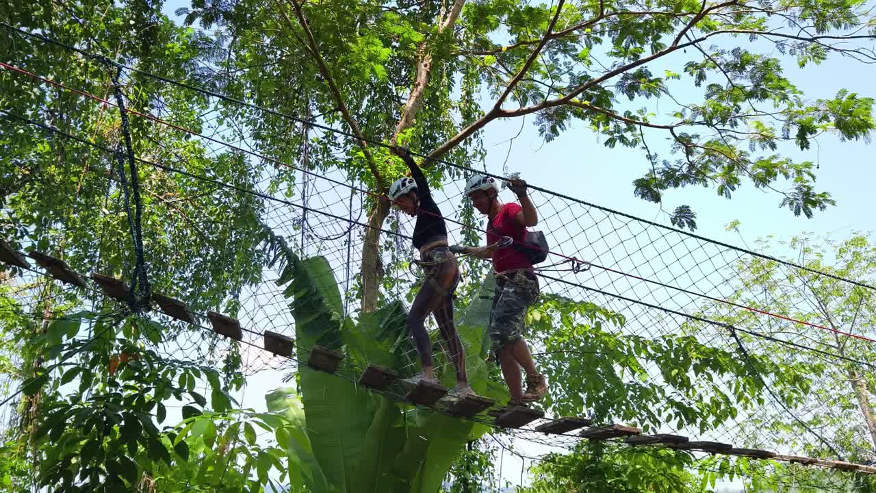 Couple enjoying a challenging treetop adventure park experience