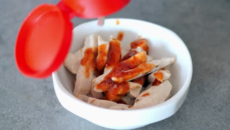 preparing a chicken sausage dish with sauce and mayo