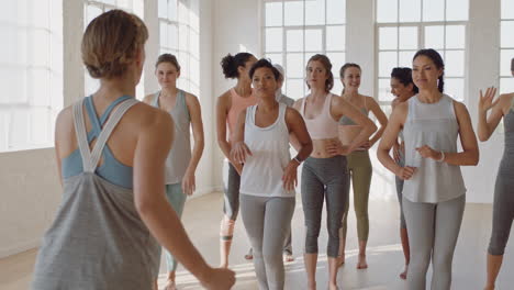 group of multi ethnic women learning dance moves enjoying fitness instructor teaching dancing choreography showing routine having fun in studio