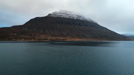 Aerial-Dolly-In-of-Fjord-in-Iceland-and-Mountain-with-Snowy-Peak
