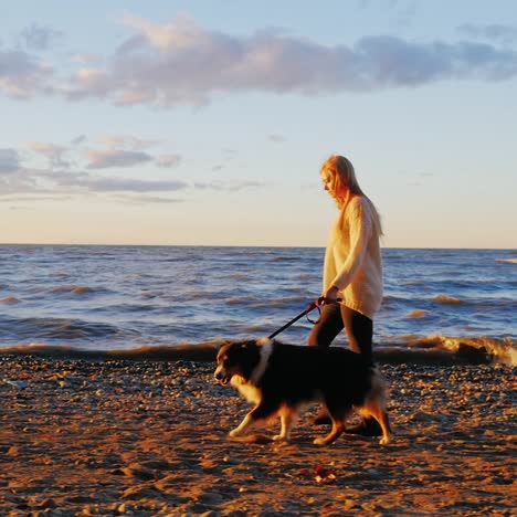 A-young-woman-walking-her-dog-at-sunset-by-a-lake-5