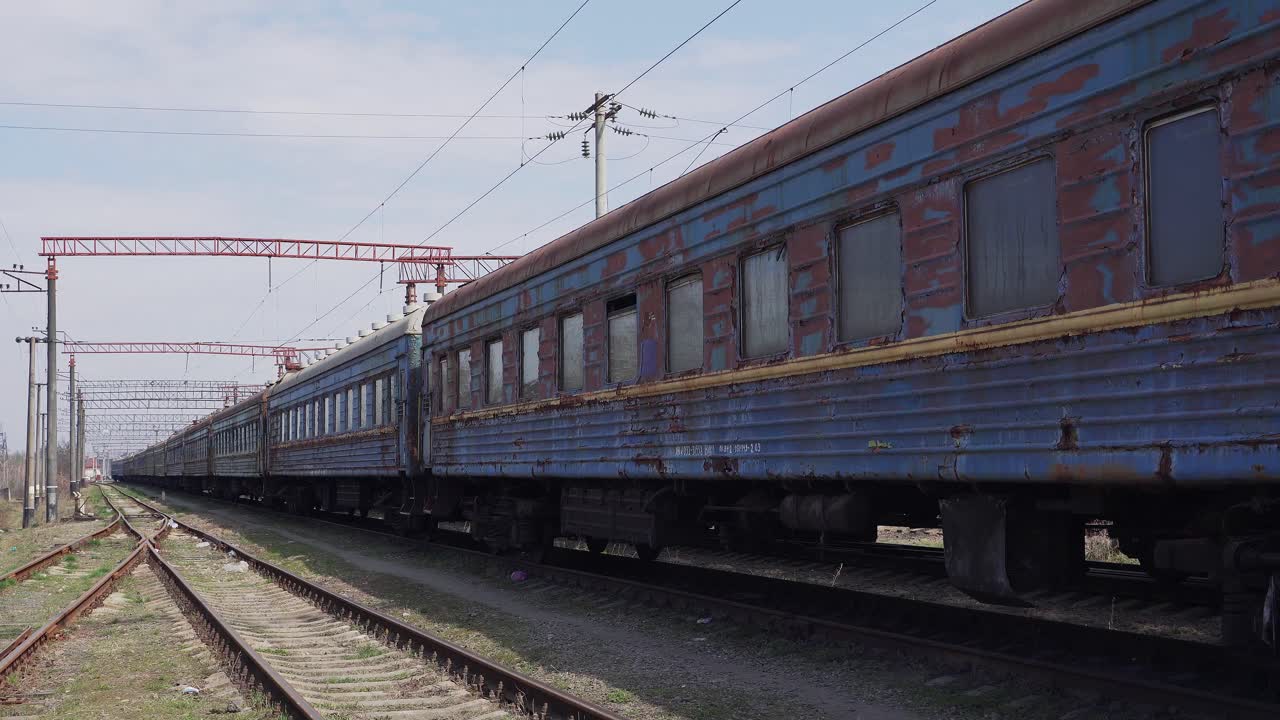 Old rusty blue train on rails. Soviet railway cars in a landfill. Peeling paint. Railway depot