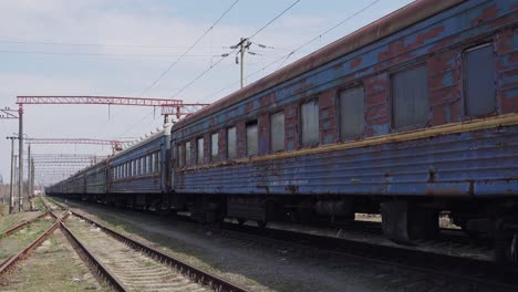 old rusty blue train on rails. soviet railway cars in a landfill. peeling paint. railway depot