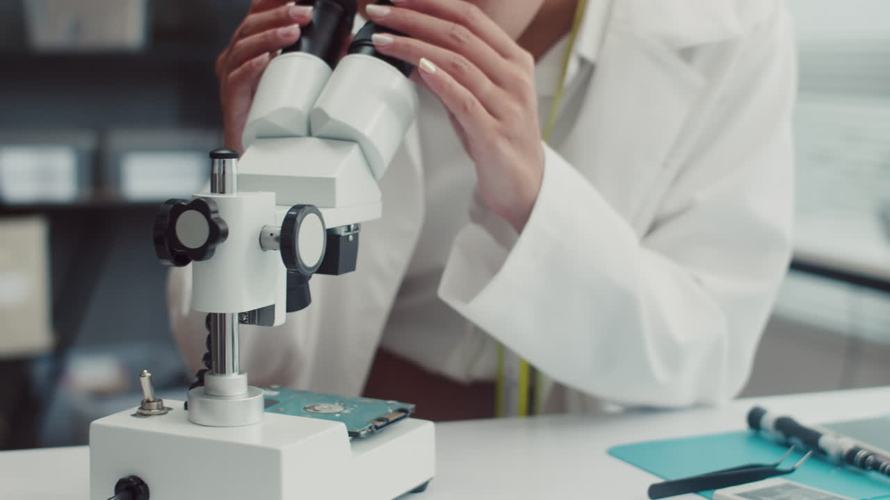 Specialist Examining Broken Detail Using Microscope