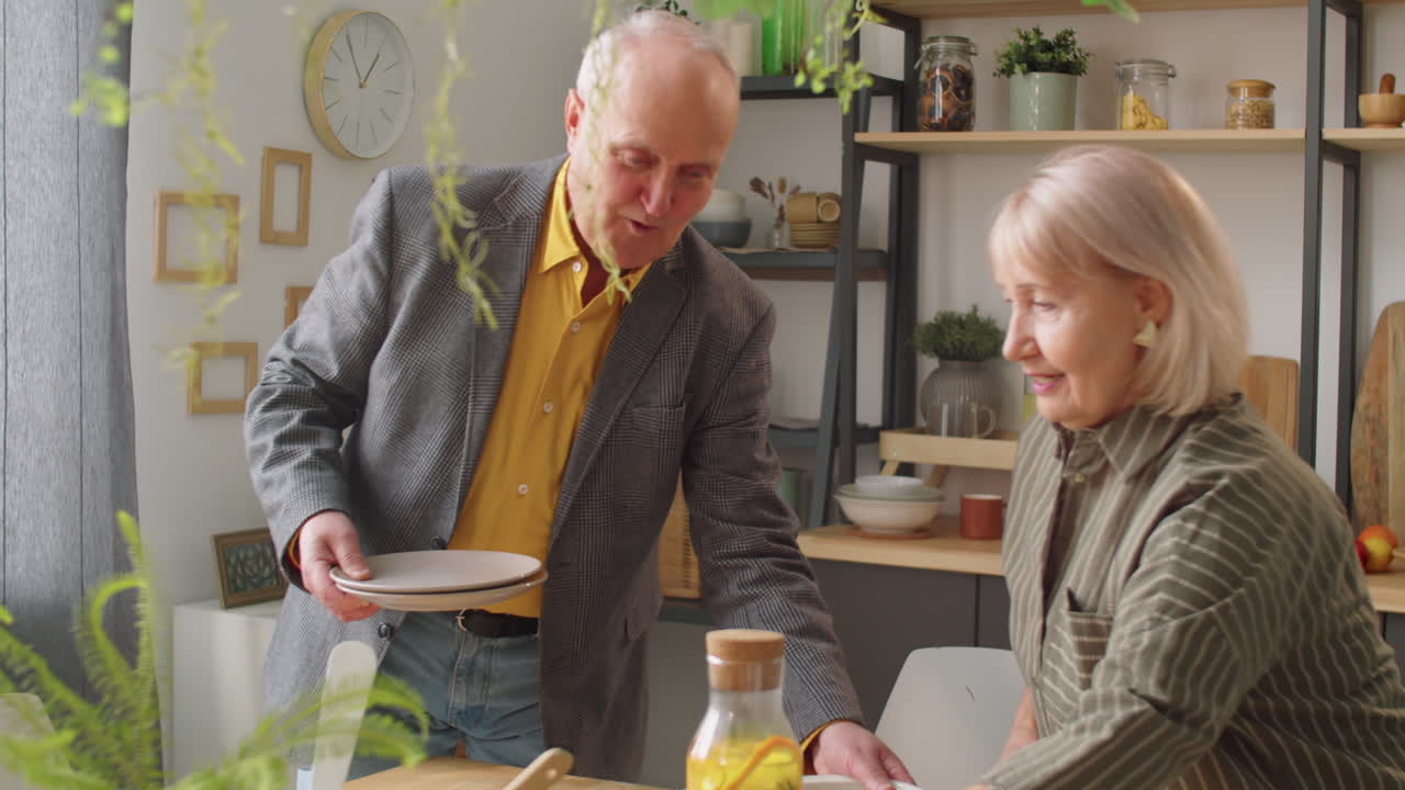 pareja de ancianos preparando la mesa de la cena juntos