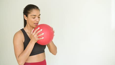 Smiling-ethnic-sportswoman-exercising-with-fit-ball